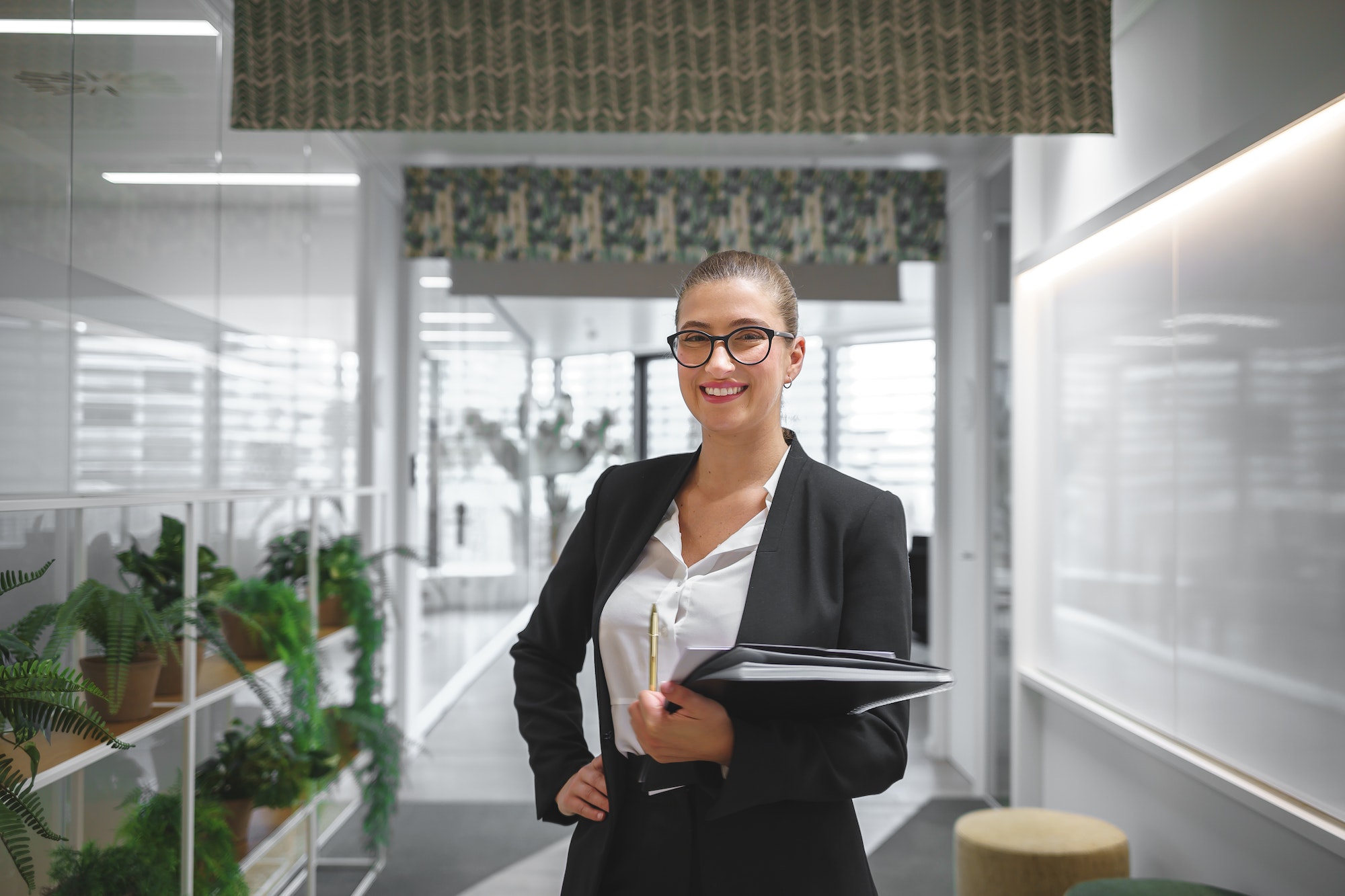 Positive businesswoman in suit in office